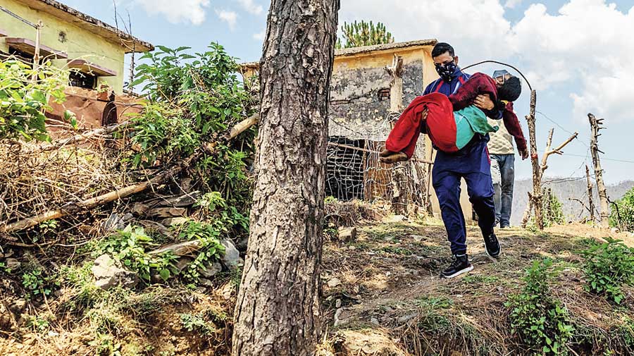 Rajesh carries Pramila to a local  government dispensary.