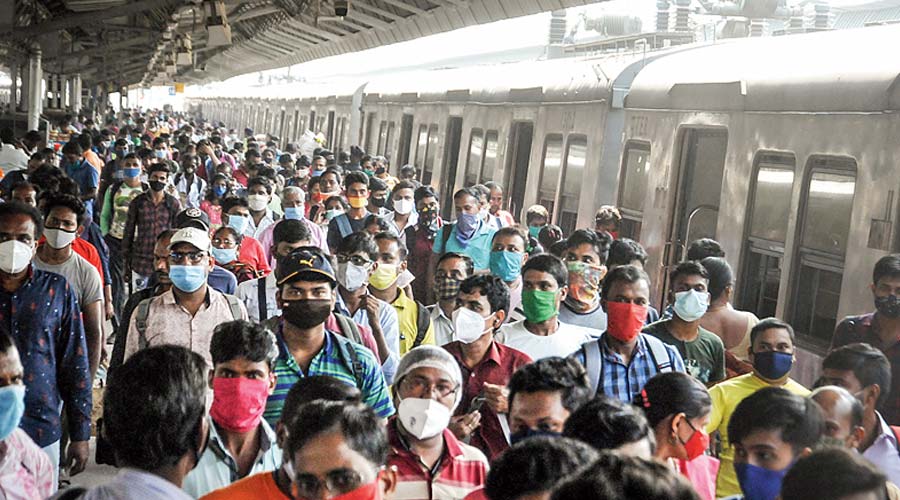 Passengers de-board from a local train after the resumption of local train services with fifty percent capacity, at Sealdah station in Kolkata, Sunday, Oct. 31, 2021