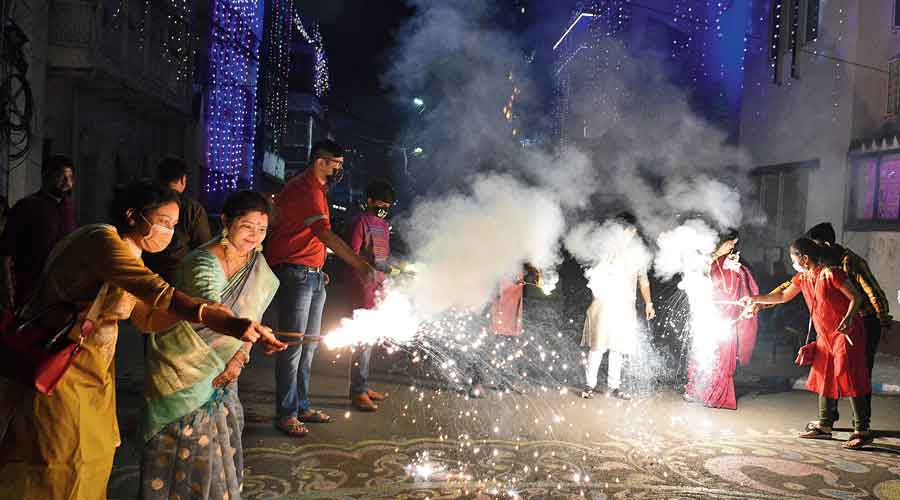 Residents of Mudiali in south Kolkata light sparklers on Thursday evening
