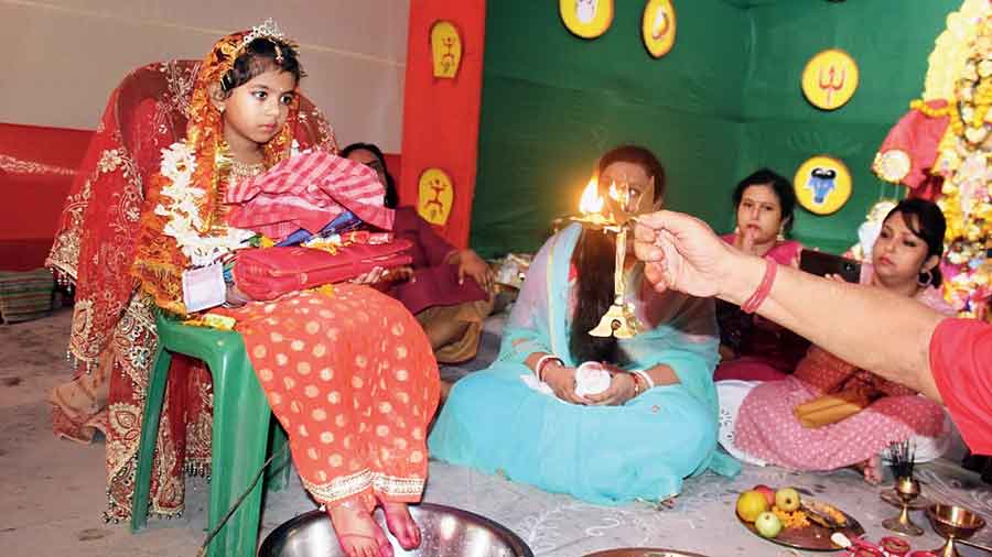 Shanvi Singh sits dressed as Kumari as arati is offered to her on Navami