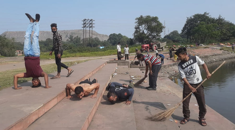 Volunteers of NGO “Samadhan” perform Yoga and Aerobics as they start Chhath ghat cleaning during their cleanliness awareness programme at Tejan Singh Talab in Jharia.