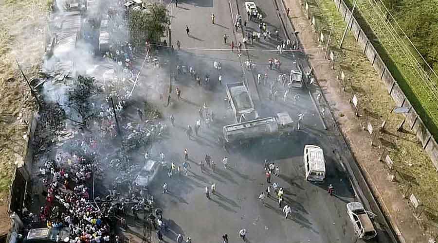 People gather around the charred oil tanker after  the explosion in Freetown, Sierra Leone, on  Saturday.