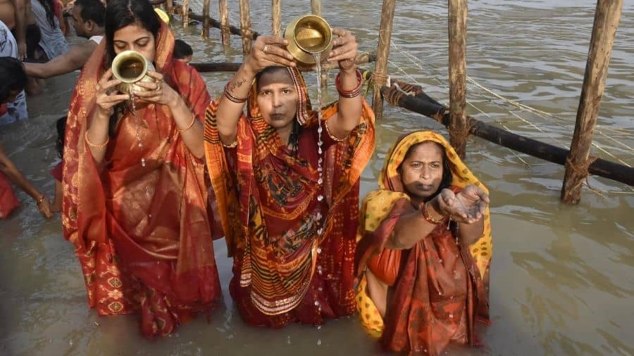 Hindu women offer prayers to Sun other after taking bath in the holy Ganga River during the Kharna Puja of the Chhath celebrations, in Patna on Tuesday.