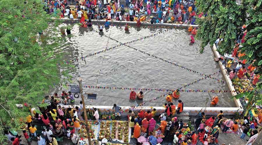 Devotees perform Chhath Puja rituals at an artificial pond in Panditya on Wednesday.