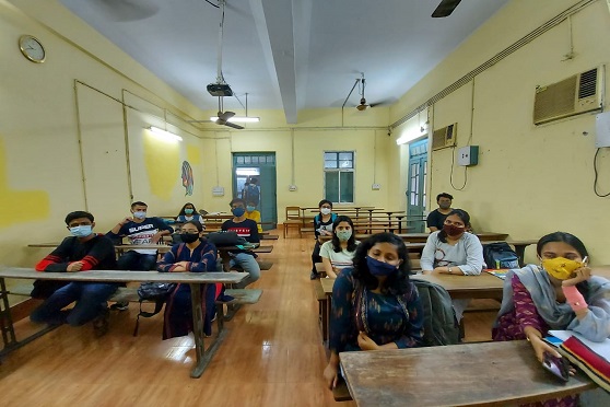 Students listen attentively to a virtual lecture in a classroom.
