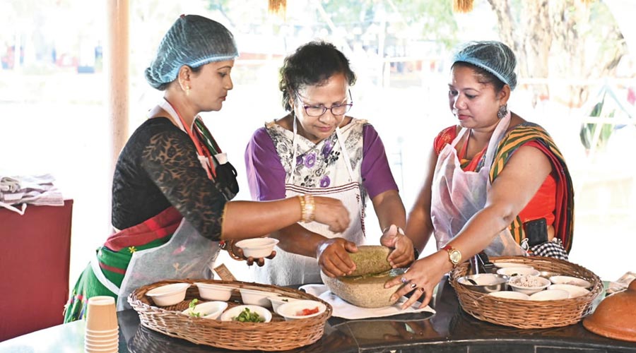 Participants prepare various dishes to present tribal cuisine during the Samvaad  in Jamshedpur  on Tuesday. 