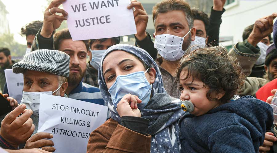 Families members of Altaf Ahmad Bhat and Dr Mudasir Gul, who were killed during an encounter between security forces and militants at Hyderpora Yesterday, shout slogans and hold placards during a protest demanding a probe and return of the dead bodies, in Srinagar on Wednesday..