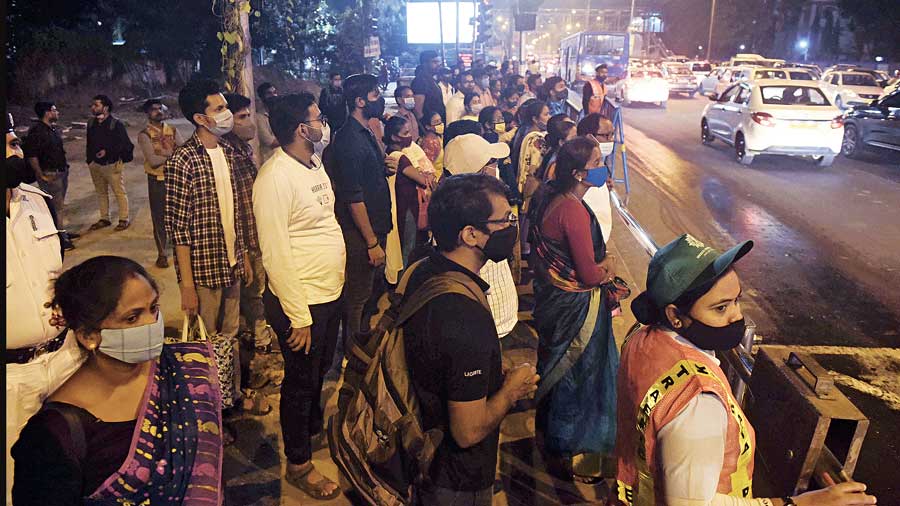 Pedestrians wait at the Chingrighata-EM Bypass crossing on Thursday evening.