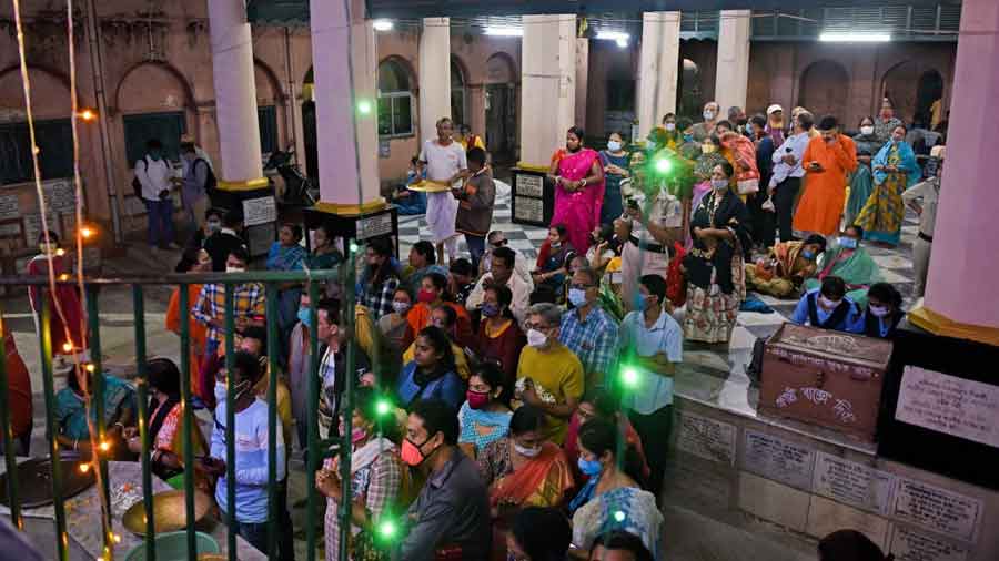 Devotees gather inside the temple premises in the evening