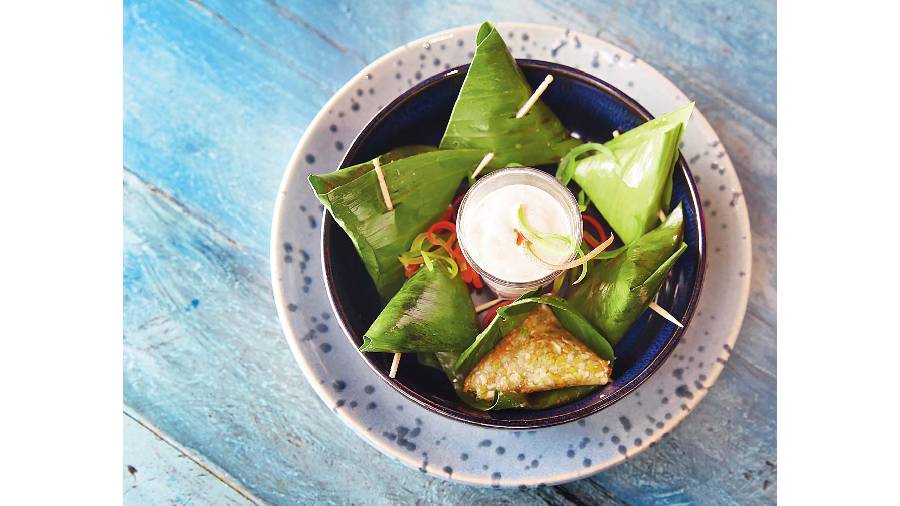 Thai Ba Blot has banana leaf wrapped over a steamed vegetable filling made with a mash of beans, carrots, bamboo shoot, asparagus and broccoli and is served with a Tzatziki dip. Rs 199