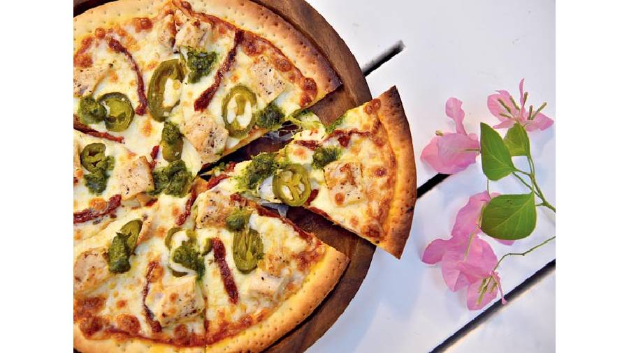 Caravan Cafe Special Chicken Pizza: Dive into this oven-baked, thin crust that’s perfectly balanced and topped with cherry and sun-dried tomatoes, jalapenos, roasted garlic and chicken. Enjoy Italy in Kolkata with this special! Rs 400