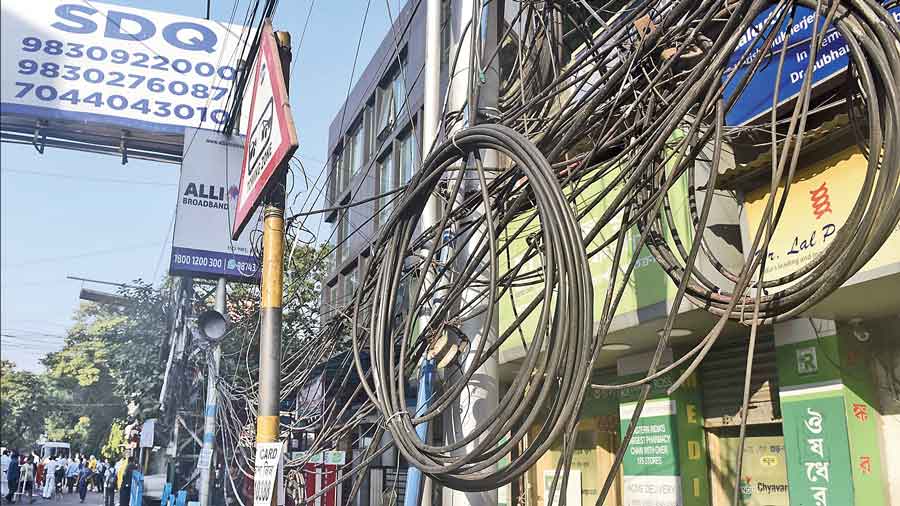 Overhead cables hang on poles Harish Mukherjee Road last week.