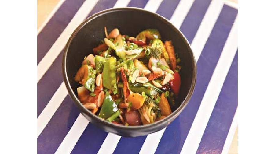 Healthy, delicious and crunchy sum up Stir Fried Asian Greens that has the goodness of soft tofu, toasted almonds and burnt garlic chips.