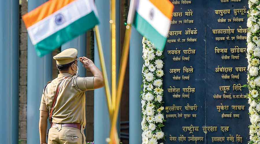 A police officer salutes the martyrs of the 26/11 attack in Mumbai on Friday,  the 13th anniversary of the terror strike.
