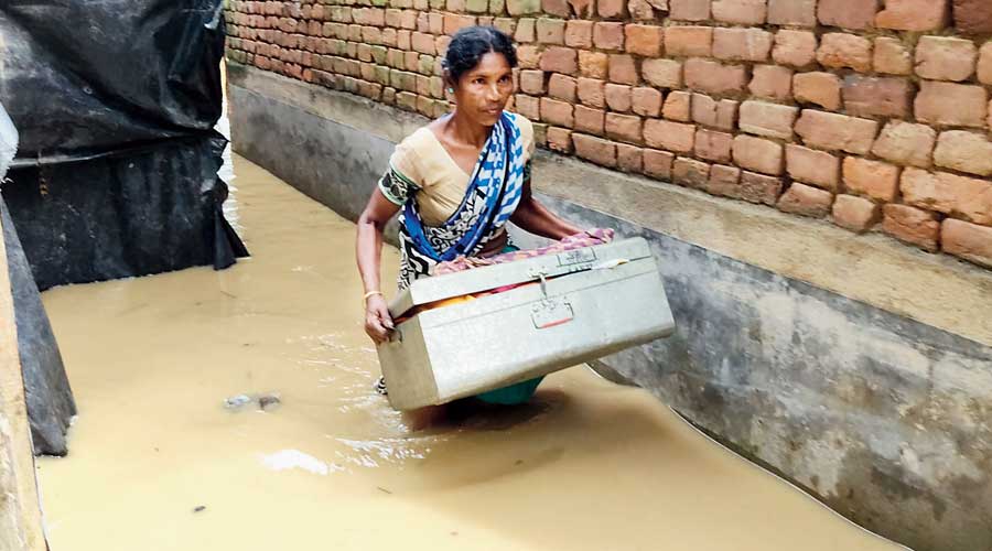 A woman with a trunk in flooded Arambagh. 