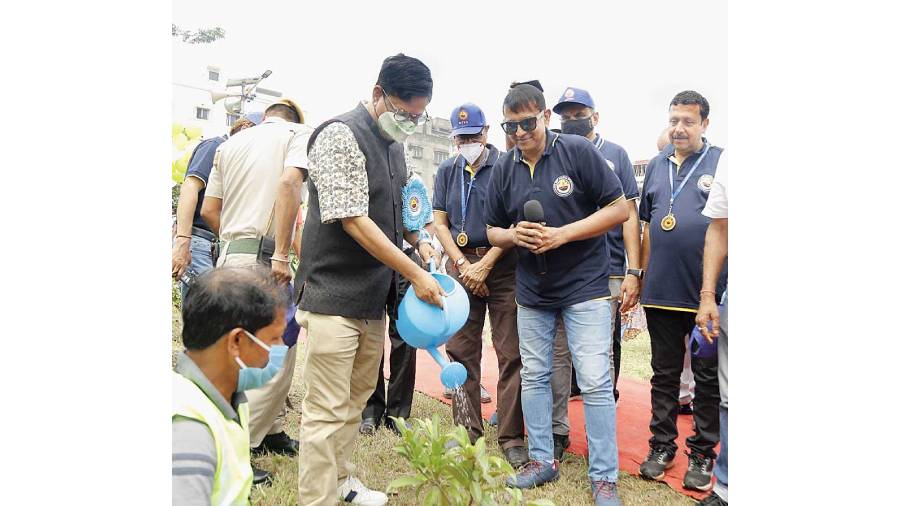 NKDA chairman Debashis Sen waters a Chiku plant at the inauguration of Green Verge 7, near Biswa Bangla Gate