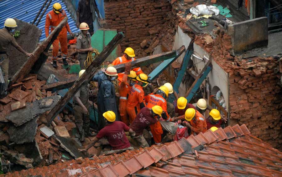 DEATH IN THE MORNING: Disaster management personnel rescue a family stuck under the debris of a collapsed building in Ahiritola early morning on Wednesday, September 29. A woman and her three-year-old granddaughter died in the mishap. Kolkata Municipal Corporation had declared the building dangerous nine years ago