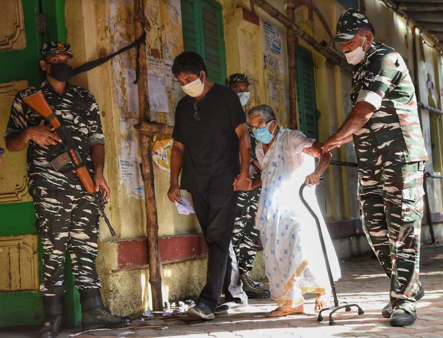 FRIENDLY FATIGUES: Security personnel on polling duty help an elderly voter during the byelection in Bhowanipore on Thursday, September 30. The election result will be declared on October 3