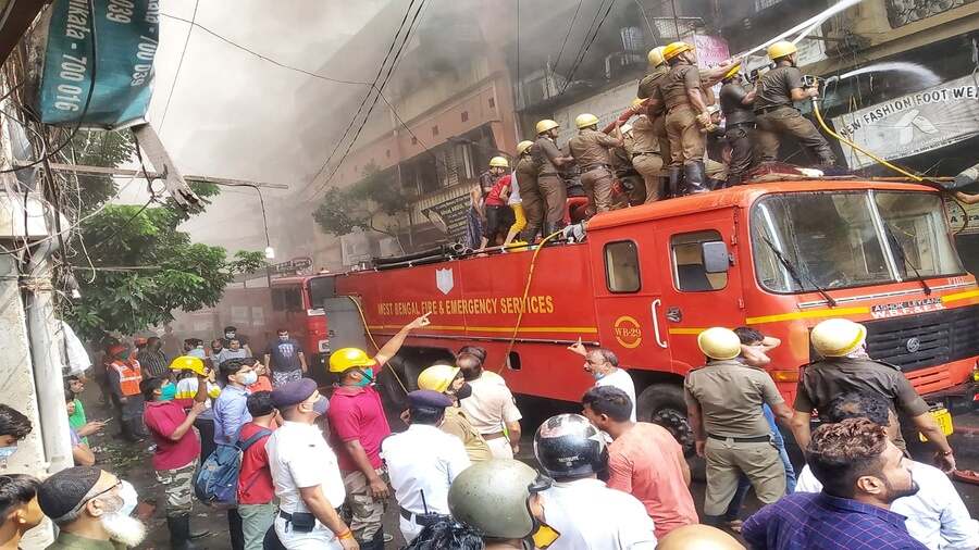 Firefighters use water jets to douse the flames at Colootola Street in north Kolkata on Monday 