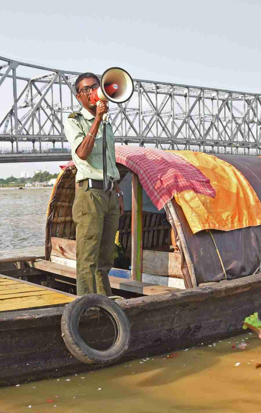 A civic volunteer warns the worshippers of the morning high tide