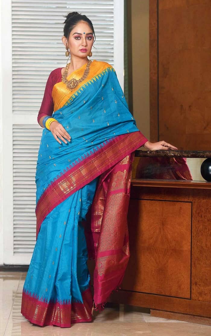 On the last day of the Pujas, if you wish to tread off the beaten track of red-and-white, go for something traditional enough in classic vibrant hues. We couldn’t let you celebrate Vijaya Dashami without a burst of colours. Don this turquoise cotton-silk gadwal with Ganga Jamuna borders and a striking zari pallu as you say ‘Ashchhe bochhor abaar hobe’!