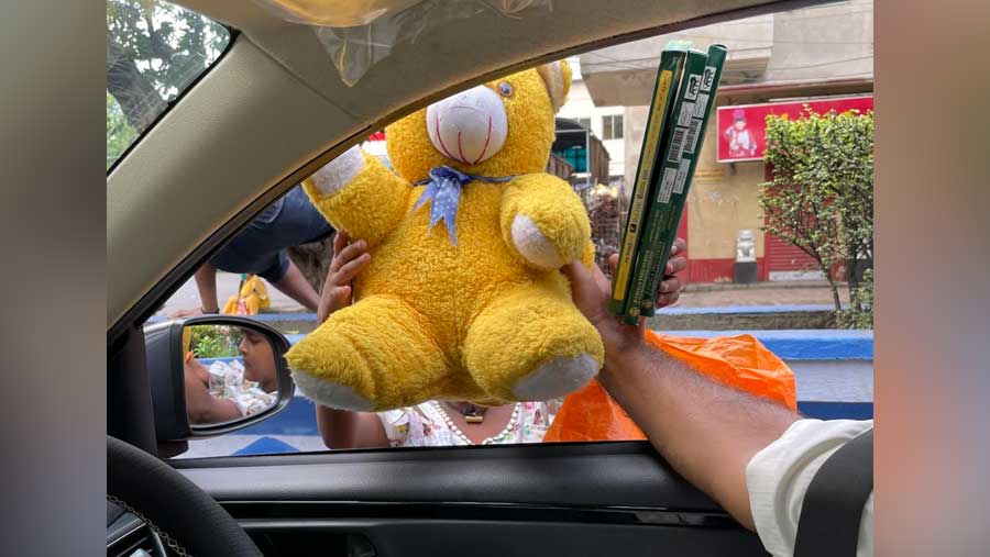 A child vendor selling incense sticks receives a teddy bear