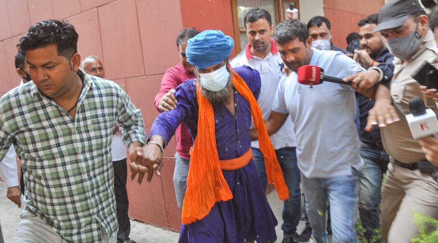 Sarabjit Singh, accused in the murder of Lakhbir Singh near farmers protest at Kundli border, being taken back to police custody after the court ordered for his 7-day remand, in Sonipat, Saturday, Oct. 16, 2021. 