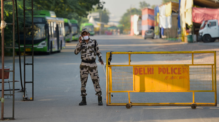 A security person keeps vigil at Singhu Border near the site of the farmers protest, in New Delhi on Friday.