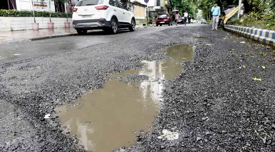 Potholes on a road in front of Haveli Restaurant in CK Block near Tank No. 9.