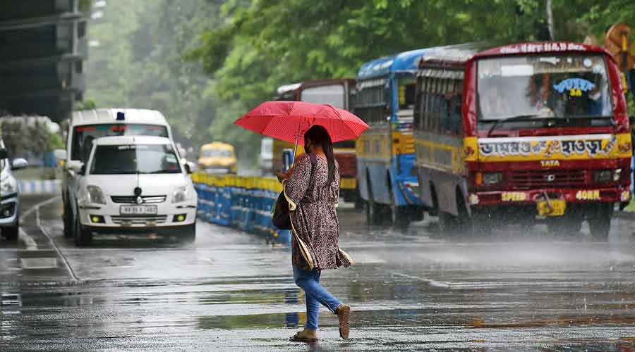A pedestrian crosses JL Nehru Road in central Kolkata amid rain around noon on Monday. 
