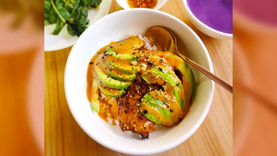 A salmon rice bowl, topped with avocados