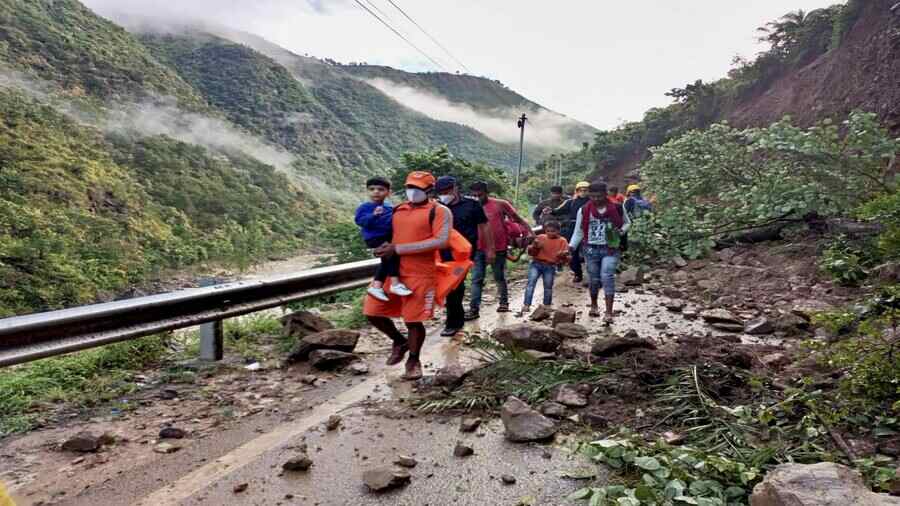 National Disaster Relief Force personnel evacuate stranded tourists from the landslide affected area of Khairna in Nainital on Wednesday following heavy rain in Uttarakhand. 