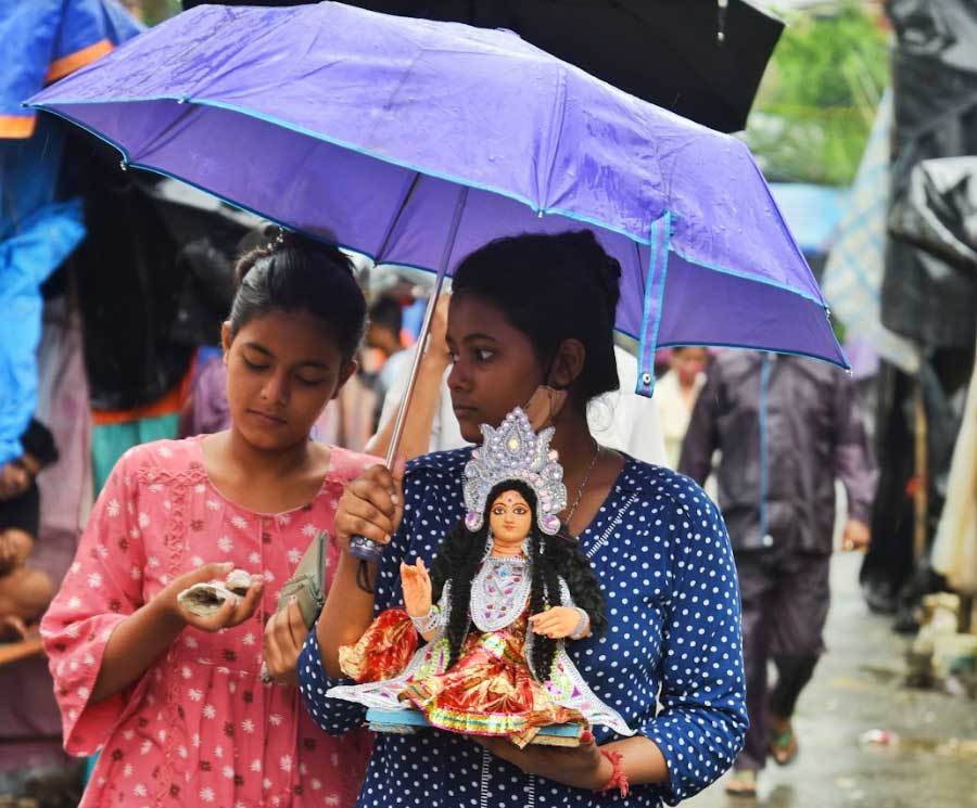 FAITH IN THE TIME OF RUNAWAY PRICES: A Lakshmi idol goes home from Kumartuli on Tuesday, October 19. The shadow of price rise loomed large over the worship of the goddess of wealth.