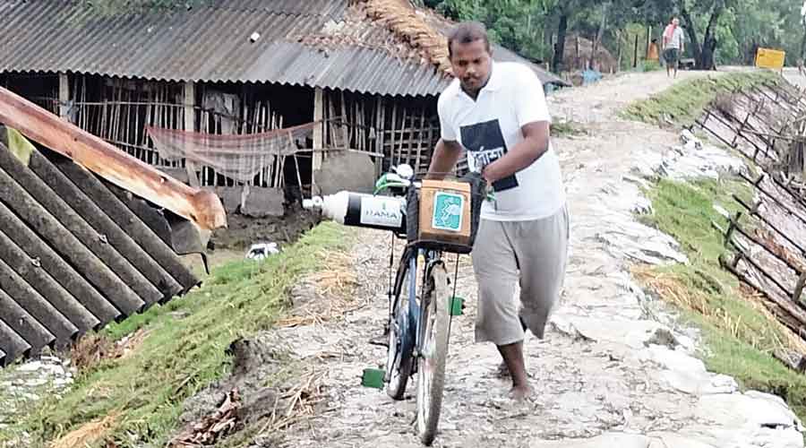 Volunteer Soumitra Mondal carries an oxygen cylinder on his cycle.