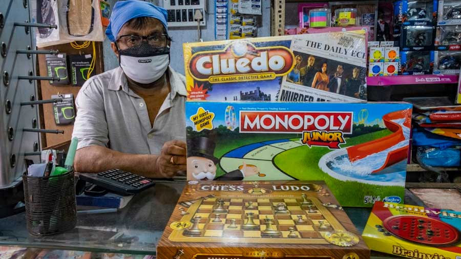 Lakshminarayan Mallick, the owner of the toyshop Striker, poses with the most popular board games in his store