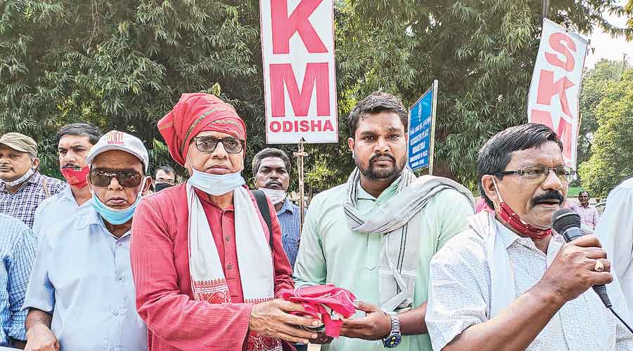 Sachin Mohapatra (right)  and other members of the Samyukta Kisan Morcha at the protest in Bhubaneswar on Tuesday with the farmers’ ashes urn