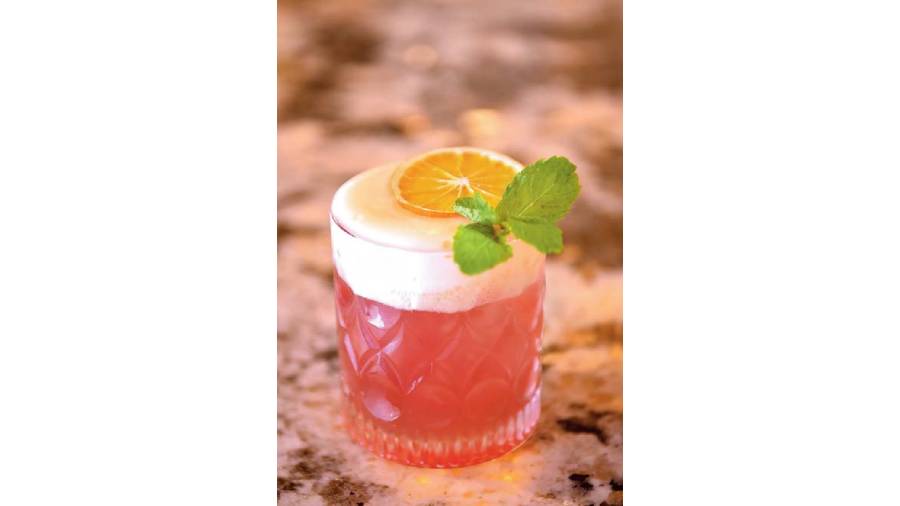 Optimistic is a Bourbon whisky with pomegranate and mint with an oozy effect of orange foam and garnished with mandarin slice and mint.