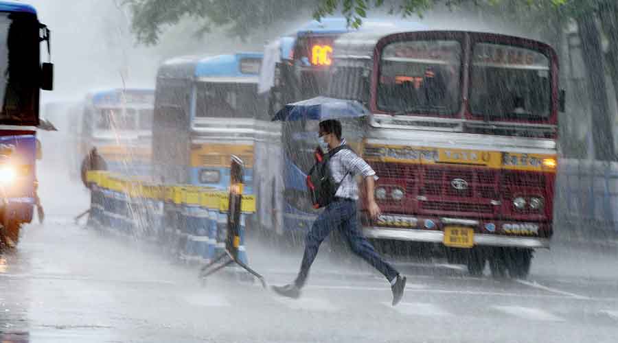 A pedestrian runs across JL Nehru Road in central Kolkata amid rain on Tuesday.