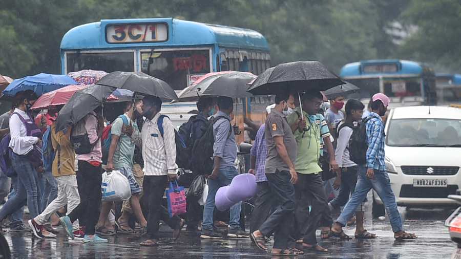 Pedestrians carrying umbrellas cross a road during rain in Kolkata, Tuesday, Sept 14, 2021.