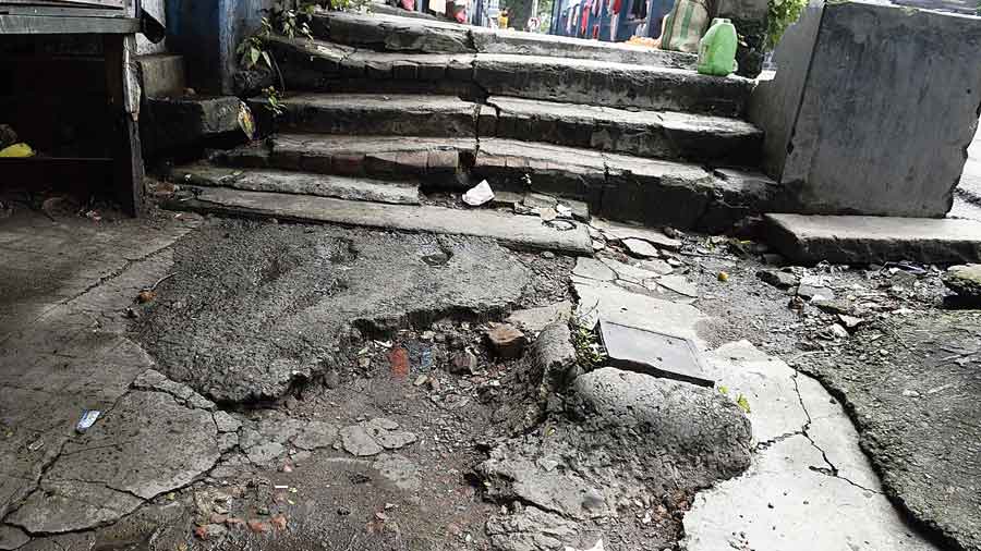 An iron slab juts out of a broken pavement in front of Maniktala police station. 