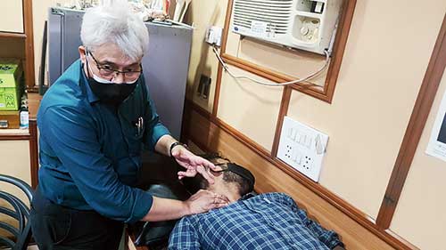 Dr Debasis Datta teaches how to check carotene pulse and (below) how to hold a victim so he can breathe easily