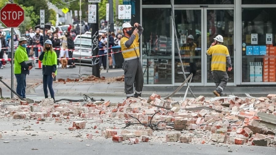 People are seen examining damaged buildings along Chapel Street following an earthquake on September 22, 2021 in Melbourne, Australia.