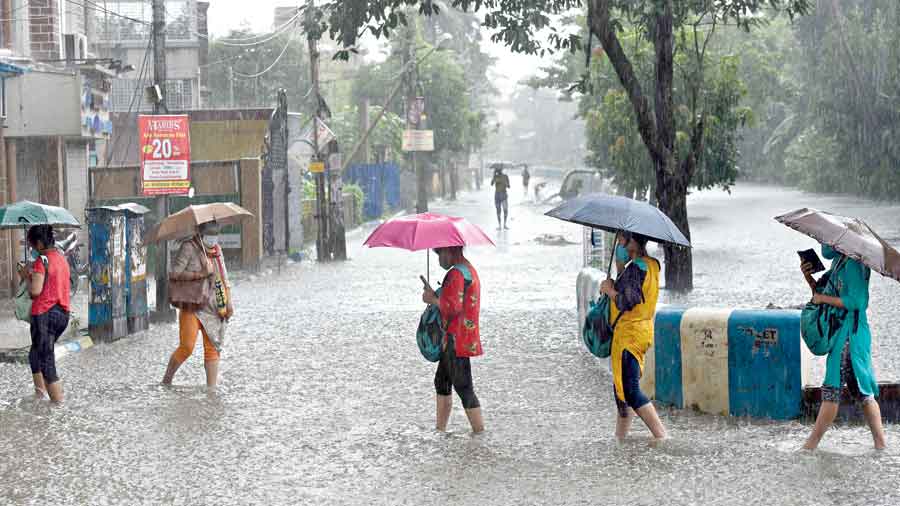 Pedestrians on a waterlogged stretch in Mukundapur on Wednesday afternoon.  