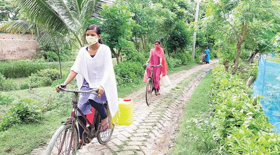 Toma Das (in white dupatta) with other girls of Hulorchar village of Hansnabad block of North 24-Parganas bring drinking water on cycles. 