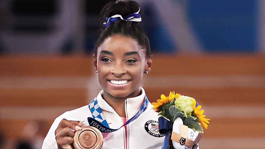 Simone Biles poses with her bronze medal in Tokyo in August. 