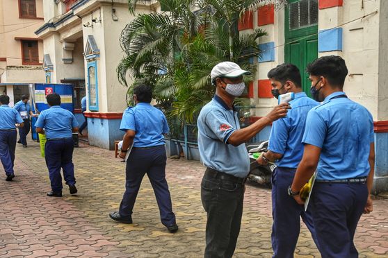 Students undergo thermal scanning outside examination centres before appearing for the Class XII board exams that began on April 2 amid strict COVID protocols. 