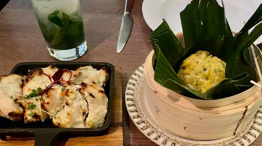 Nizami Malai Tikka served in a cute iron skillet and the Kakra Chingri Bhapa wrapped in a banana leaf