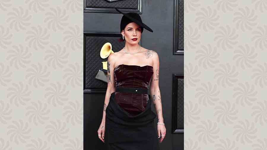 A velvet corset top teamed with a black skirt and that hat! Halsey looked stunning on the red carpet as she blended edgy (thanks to her razor-sharp contoured cheeks, bold lined lips and eye make-up) with a hint of classy. The overall look was striking.