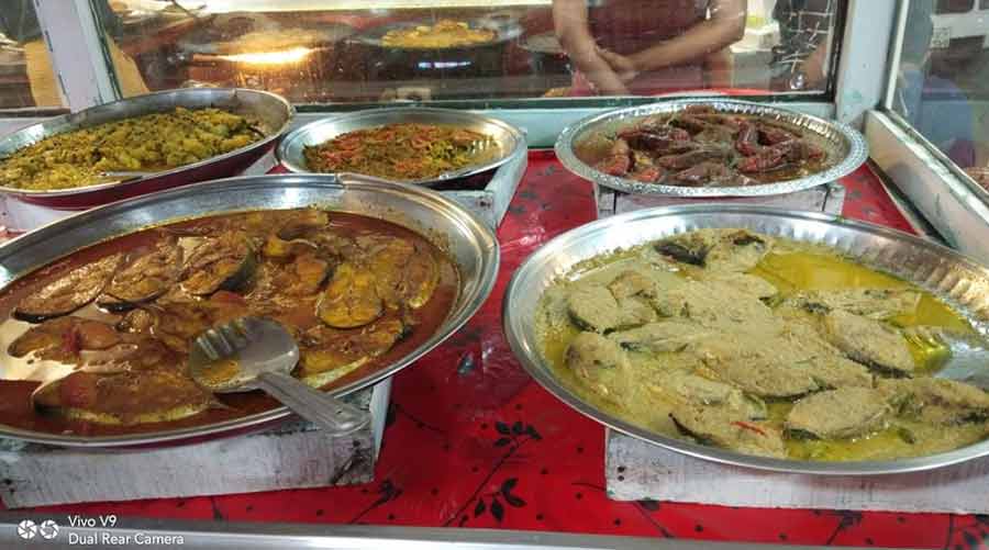 Different preparations of ilish displayed at a restaurant 