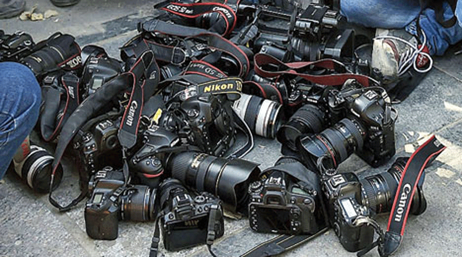 Photojournalists place their cameras on the ground outside the police headquarters in Delhi.